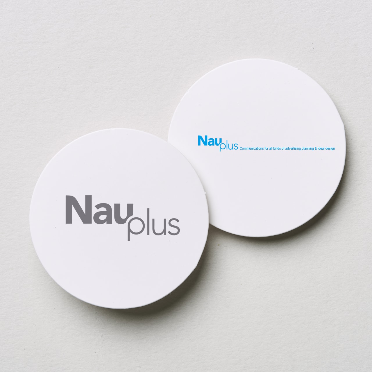 나우플러스 로고 디자인 원형 코스터 목업 정면 – 그레이 컬러 Nau plus 워드마크
